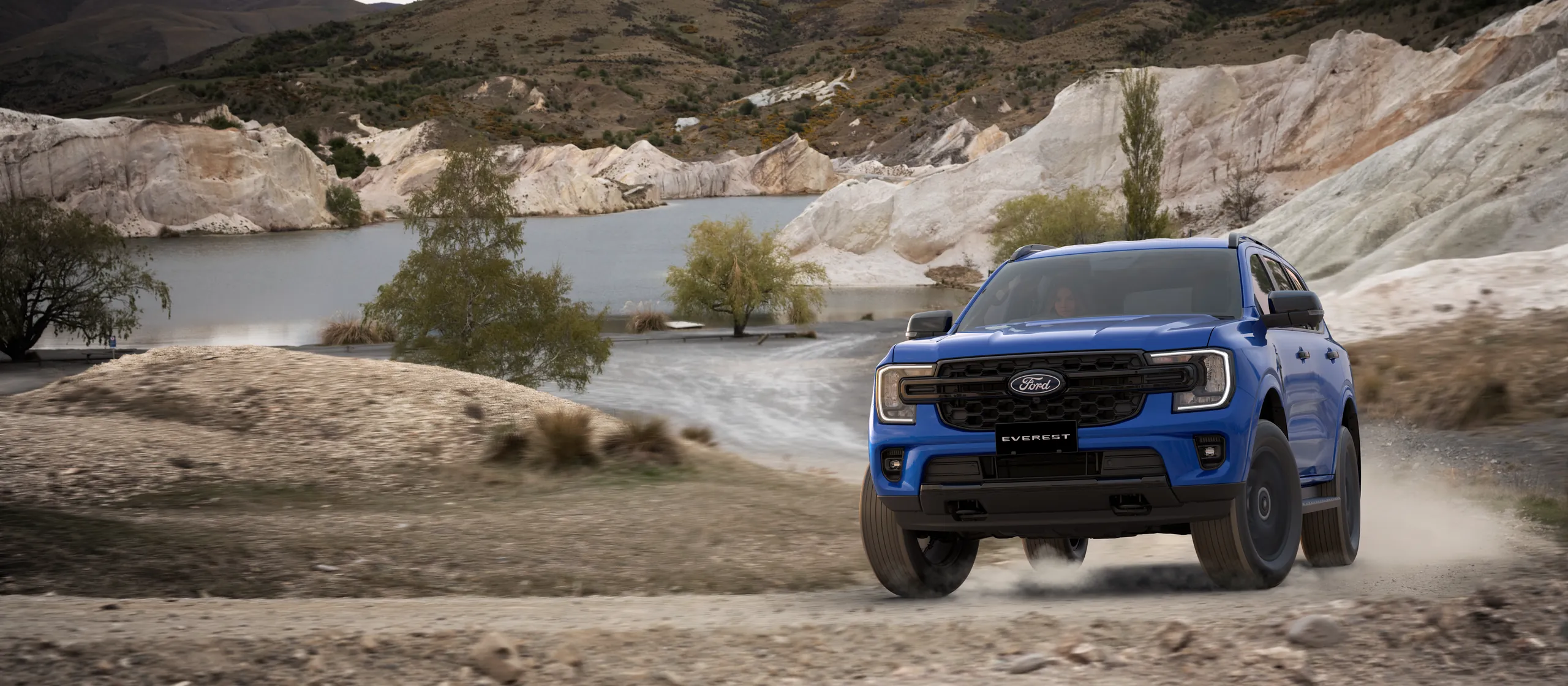 Ford Everest Sport driving on a gravel road beside a lake